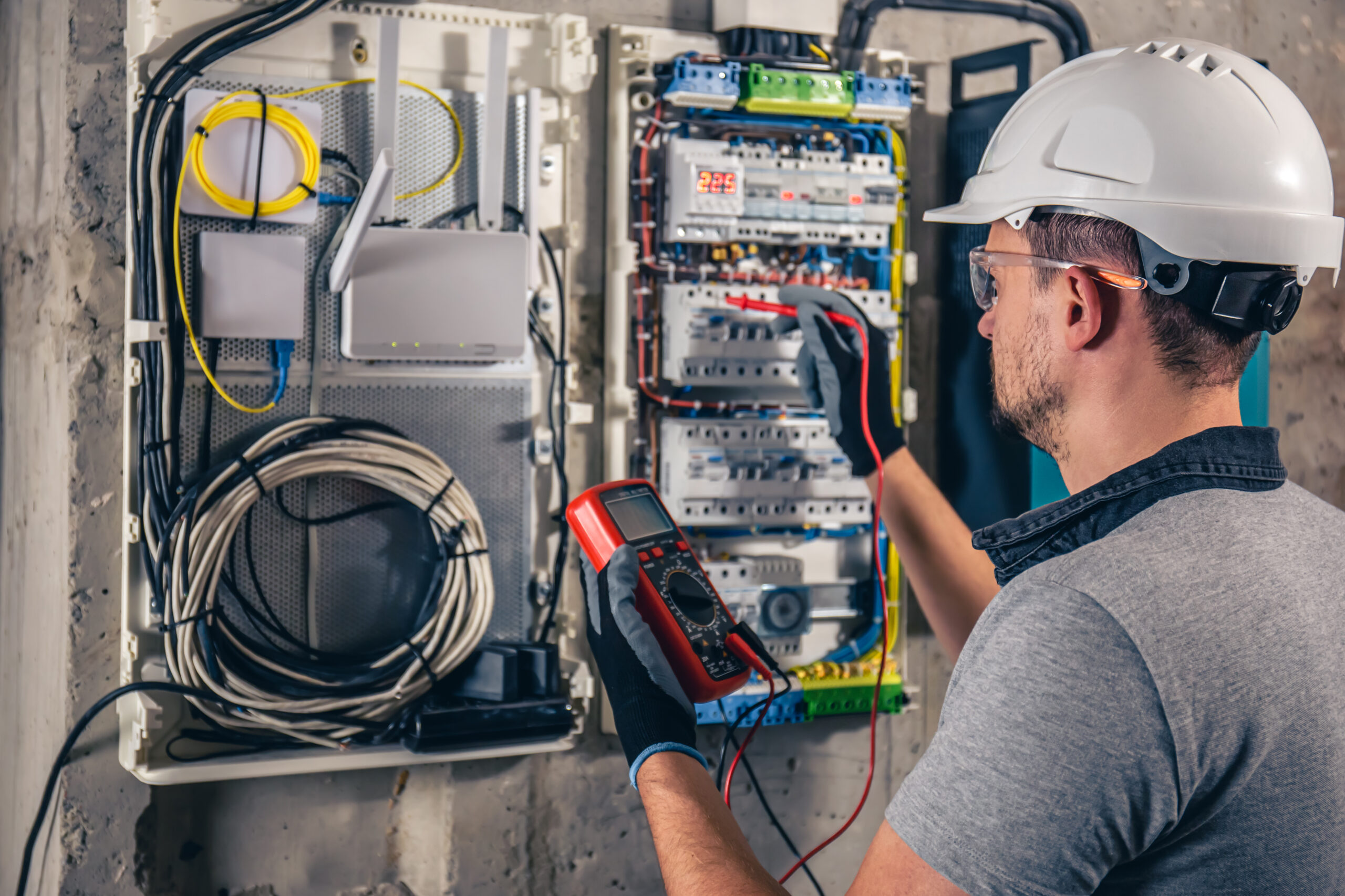 man electrical technician working switchboard with fuses scaled